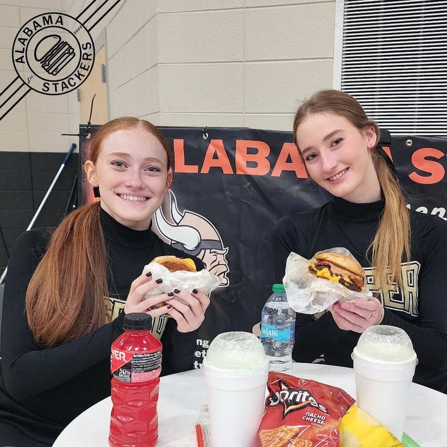 Two friends in Jasper gear with burgers